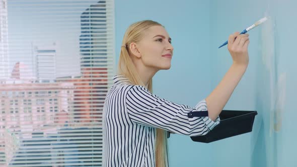 Close-up Shot of Woman Drawing a Flower on the Wall. alt