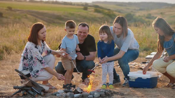 Happy Family with Children Around the Campfire on a Picnic alt