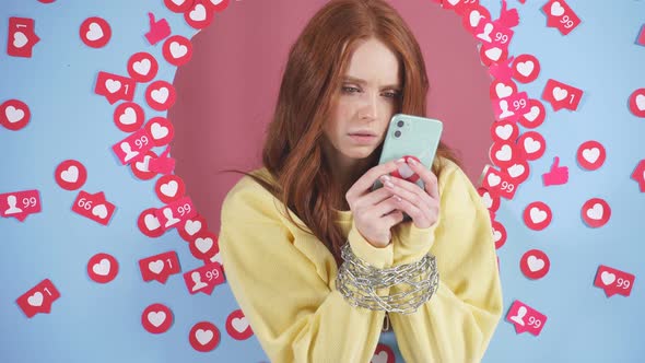 Redhaired Woman with a Smartphone in Her Hands on a Blue Isolated Background
