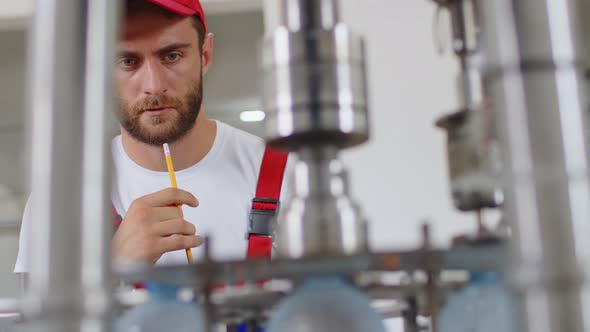 Young Man Worker of Water Factory Checking Quality and Making Inspection in Line Production