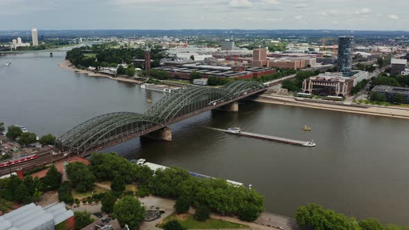 A Large Ferry Floats Under a Bridge Located in the Historic Center of Cologne alt