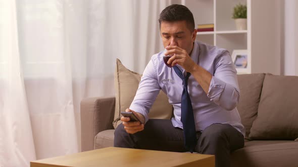 Alcoholic with Smartphone Drinking Wine at Home  alt