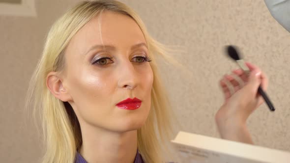 Master Applies Powder Bronzer Contouring on Young Model with Special Brush alt