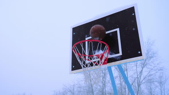 Basketball Ball Flies Into the Basket in the Winter alt