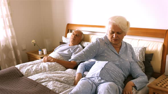 Senior woman suffering from backache sitting on bed alt