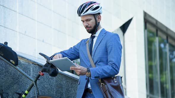 Young Businessman With Bike Using Digital Tablet