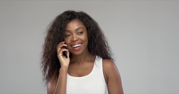 Delighted Black Woman Speaking on Smartphone