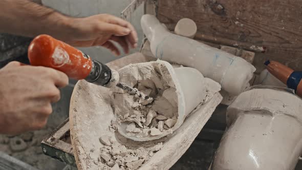 Man Removing Plaster From Plastic Cast alt