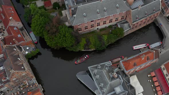 Canal with Boats Birds View in Bruges, Belgium Tilt Up To Reveal Cityscape alt
