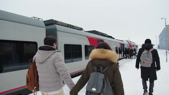 Travelers in Winter Go to Board the Train on the Platform