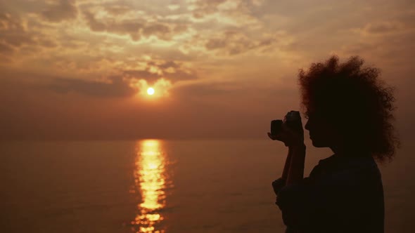 Beautiful Female Phorograph Taking Picture of Sunrise at Sea Slow Motion alt