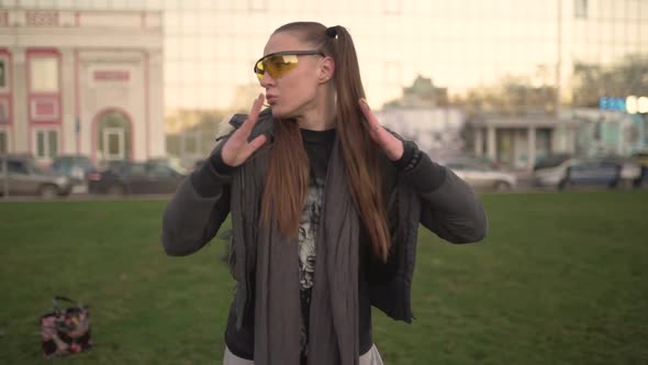 Attractive Young Hipster Woman in a Stylish Look Dancing Freestyle on Urban Background at Sunset or alt