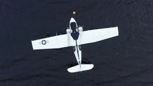 A vintage 1940's Catalina Flying boat anchored in the water. The drone climbs slowly higher while ro alt
