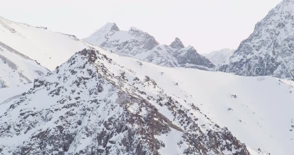 Aerial helicopter shot, flying overhead a snowy city, past long train, zoom in on military airbase,  alt