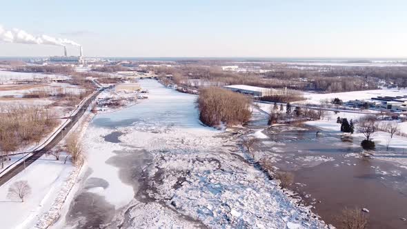 Ice Jam On The River Raisin In Monroe City, Michigan, USA  And Visible Monroe Coal Power Plant In Th alt