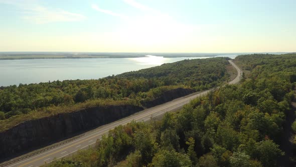 Aerial overhead high contrast shot of freeway with a few cars near ocean bay alt