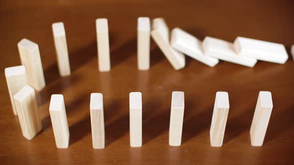 Close Up Row White Dominoes Falling on Wooden Surface. Concept Business Crash, Bankruptcy, Falling alt