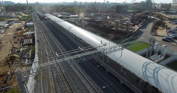 Electric Train Arriving To the Station in City Outskirts, Aerial View alt