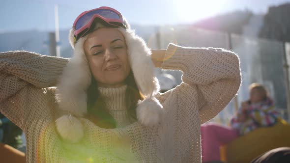 Happy Woman in Ski Resort Sitting in the Outdoor Cafes and Enjoy the Rest in the Rays of the Setting