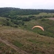 a Man with a Parachute in a Hilly Landscape - VideoHive Item for Sale