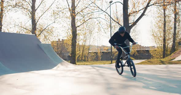 Experienced in Riding Low Bike Man with Protective Helmet on Head Approaches Camera Jumps Into alt