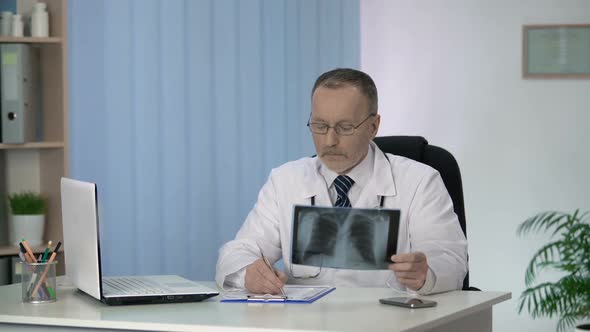 Pulmonologist Examining and Describing Patient Lungs X-Ray Scan Before Surgery alt