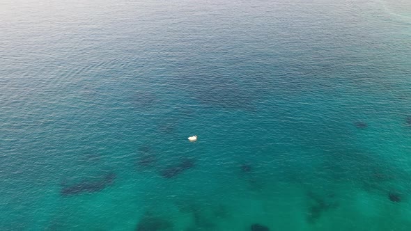 Aerial View of a Motor Boat in a Deep Blue Colored Sea. Kolokitha Island, Crete, Greece