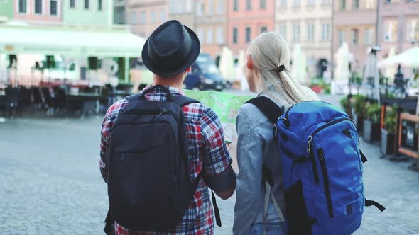 Man and Woman with Bags Checking Map on Central City Square alt