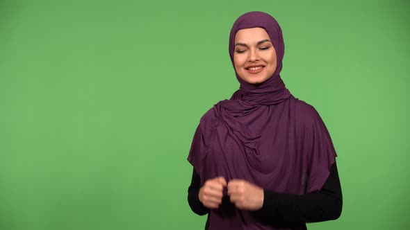 A Young Beautiful Muslim Woman Shows a Double Thumb Up to the Camera with a Smile  Green Screen