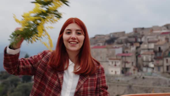 Young Girl Celebrates Women's Day with Yellow Mimosa Flowers in Hand alt
