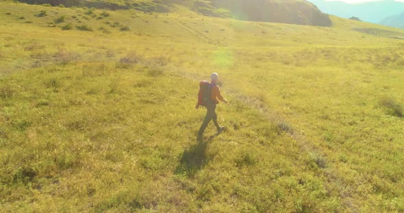 Flight Over Backpack Hiking Tourist Walking Across Green Mountain Field alt