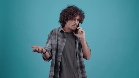 The Young Hipster Seriously Talks on the Phone Frowning Answers the Question Frustrated and Listens alt