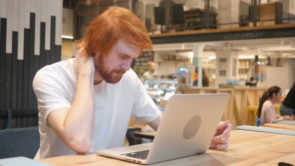 Tired Redhead Beard Man Working in Cafe alt