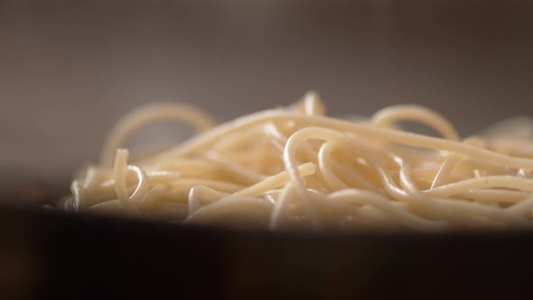 Camera follows pouring carbonara sauce over spaghetti. Slow Motion. alt