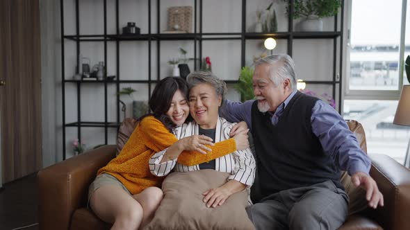 Portrait Asian family cuddling in sofa living room at home.