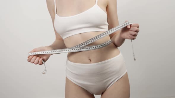 Slim Woman in Underwear Posing with Measuring Tape Isolated on White Background alt