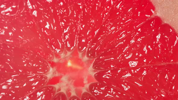 Drop of Water Flows Down the Surface of a Ripe Juicy Grapefruit Slice alt