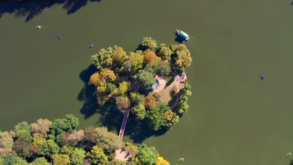 Top view of the lake and the island. People swim on a boat, boats on the lake. alt