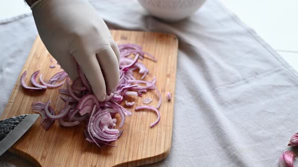 Chef Cuts Red Onion with a Knife on a Cutting Board Medium Shot