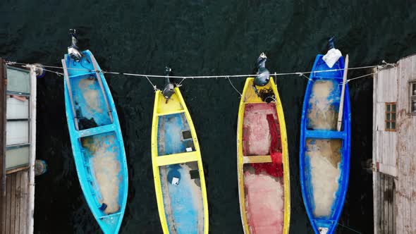 Top view of fishermen huts with moored boats. alt