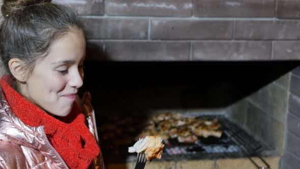 Young Beautiful Teenage Girl Eating a Piece of Meat with a Fork and Having Fun alt