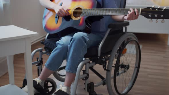 A Young Disabled Lady is Playing the Guitar and Singing Songs alt