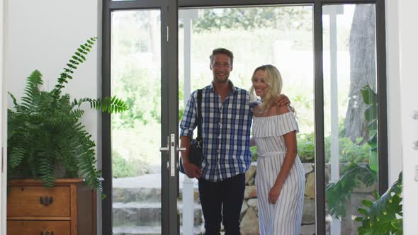 Happy couple arriving home with their daughter alt