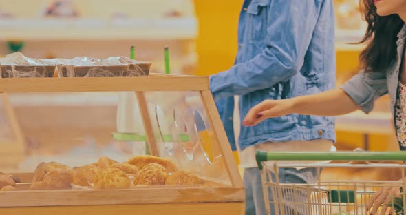 Young Woman with a Man Comes Into the Bread Department and Chooses a Bun