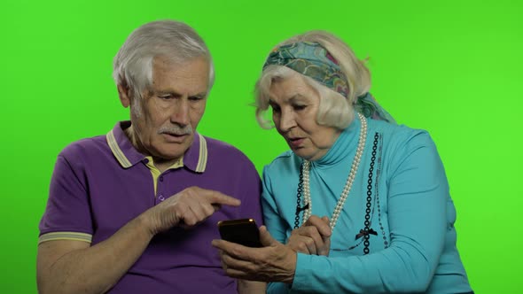 Mature Senior Old Couple Grandparents Enjoy Online Shopping on Mobile Phone alt