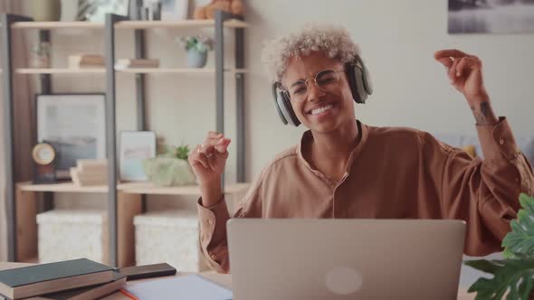 Happy African Lady with Wireless Headphones Listening Music Distracted From Work alt