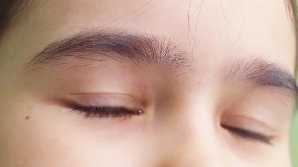 Closeup of the Brown Eyes of the Girl with a Tear Due to Contact Lenses alt