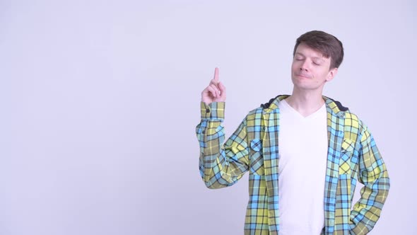 Happy Young Handsome Man Thinking and Pointing Up alt
