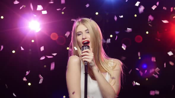 Blonde Girl Singing Into a Retro Microphone Strobe Lighting Effect alt
