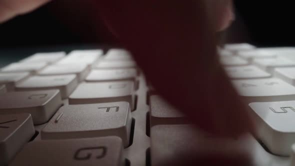 Close-up typing on keyboard with man fingers. Macro soft focus dolly shot. alt